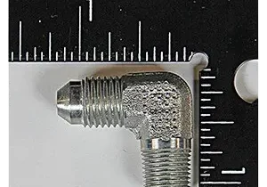 Metal elbow fitting beside measuring scale.