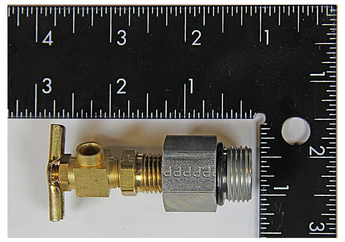 Brass valve with ruler for scale.