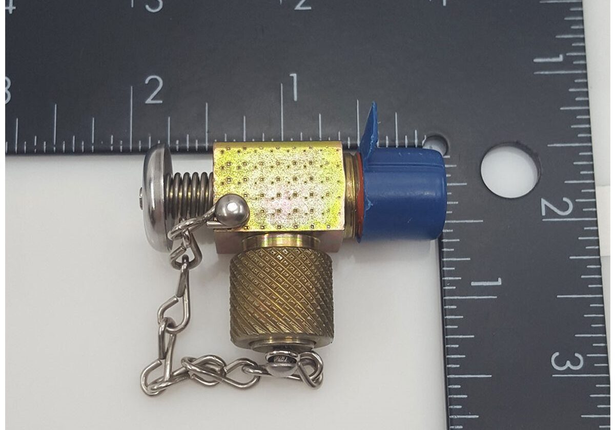 Small metal valve beside measuring ruler.