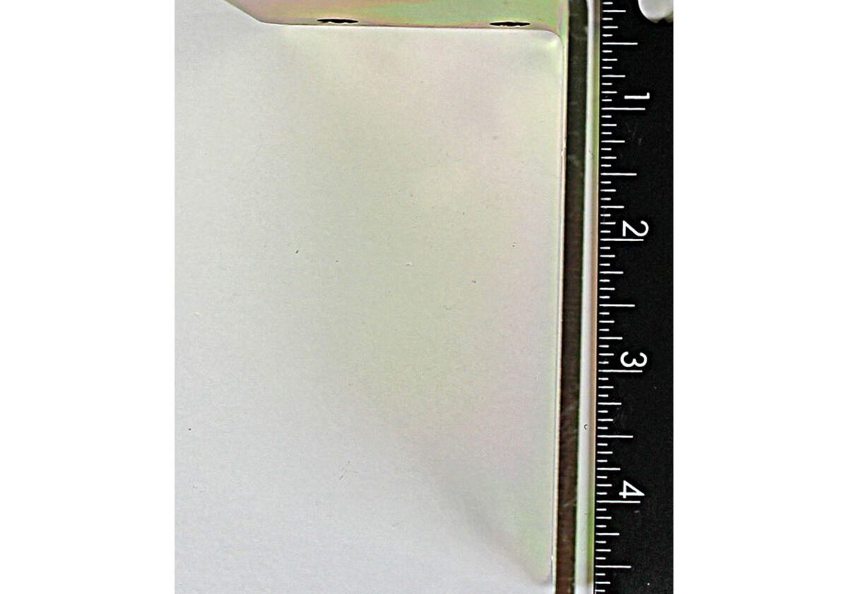 Metal bracket next to black measuring ruler.