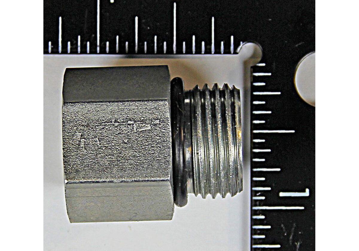 Metal hex nut beside measuring ruler.