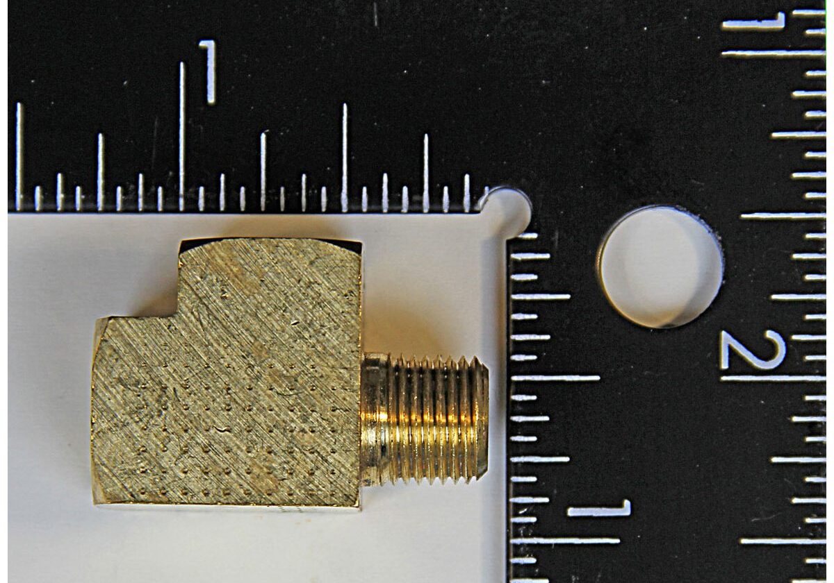 Brass fitting next to measuring rulers.