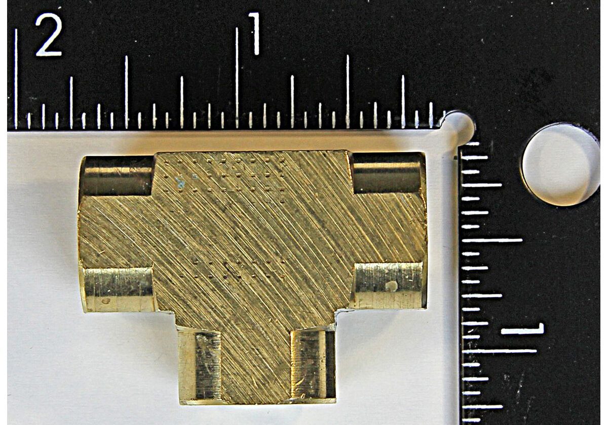 Brass connector piece with measuring scale.