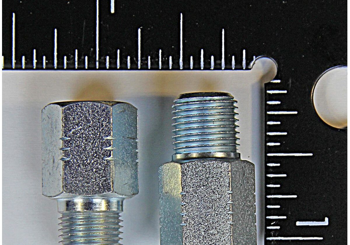 Two metal fittings next to a ruler.