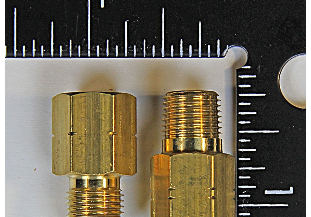 Brass adaptors with measurement scale background.
