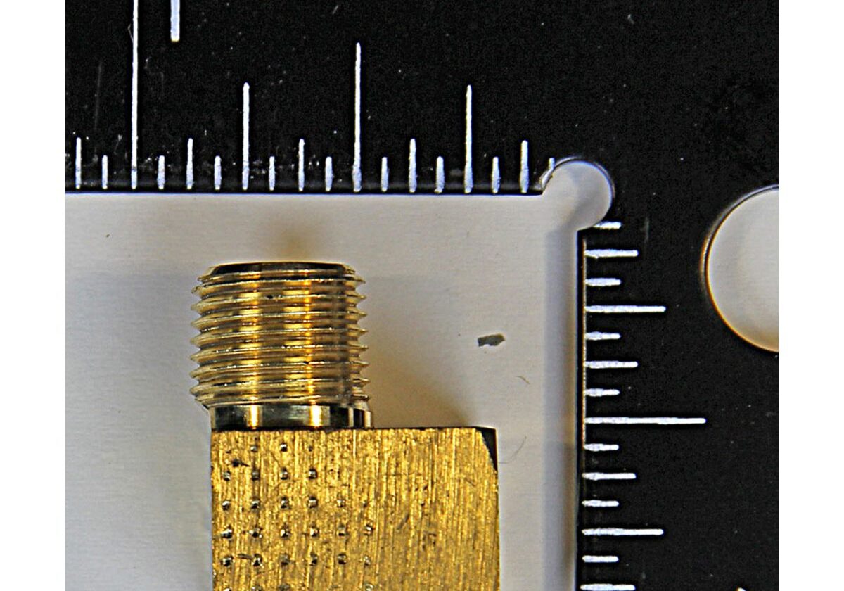 Gold right-angle adapter next to ruler.