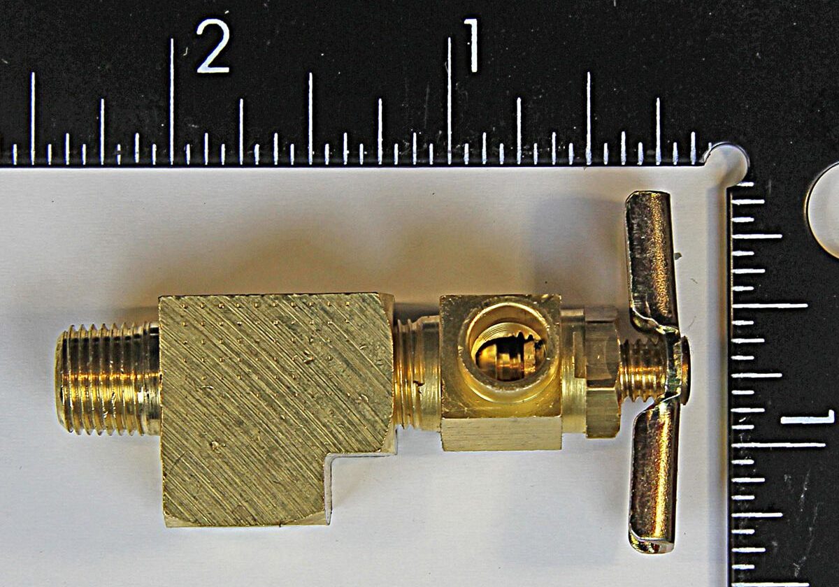 Brass valve with ruler measurements.
