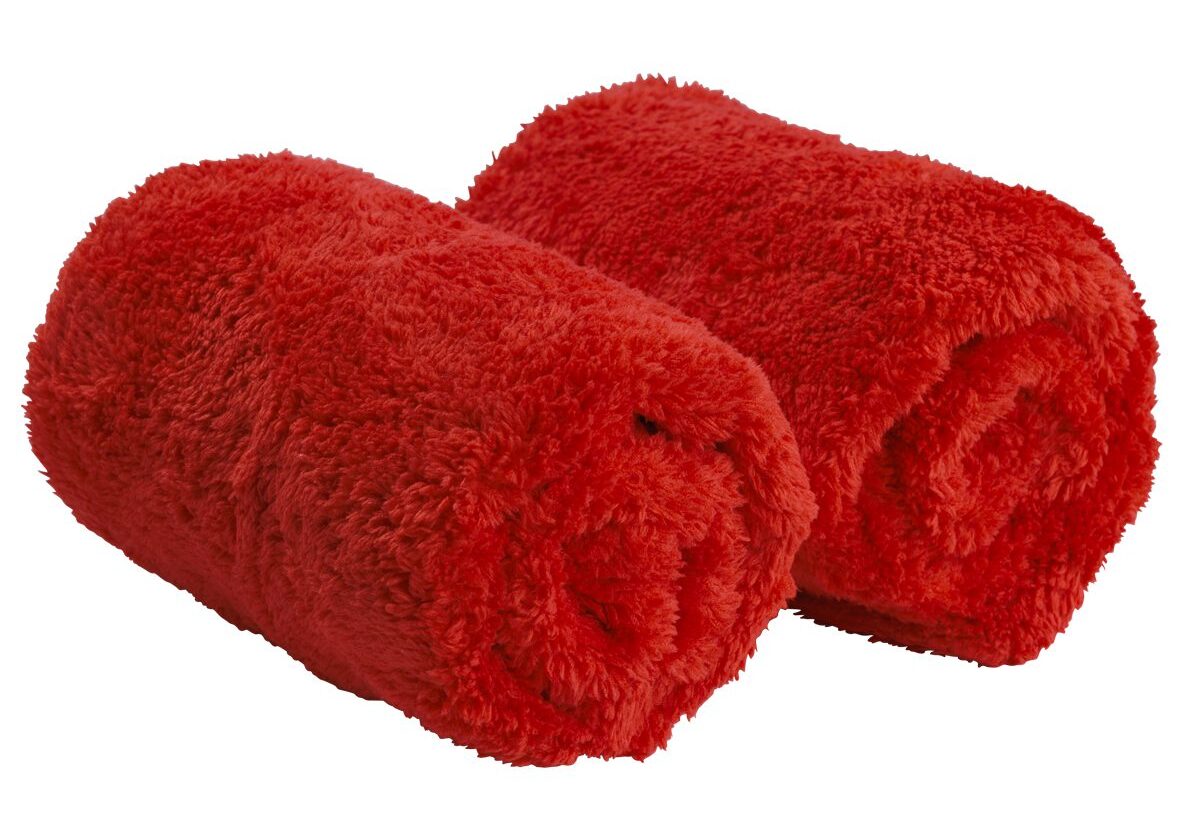 Two rolled fluffy red towels.